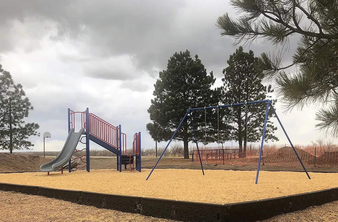 Double swing with enclosed woodchip landscaping at Matheson Park